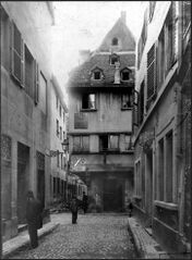 en face, maison à encorbellement du XVIe siècle, 26 rue des Chandelles. Vue depuis la rue du Vieux-Seigle, sur la gauche, la rue de la Demi-Lune (n°8)