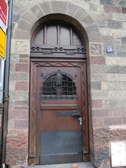 Motif feuille de châtaignier de chaque côté de la porte, repris sur la façade.