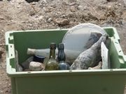 dans la caisse, bouteilles et autres objets retrouvés pendant les fouilles.