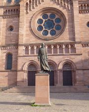 Statue de Charles Foucauld sur le parvis de l'église. On peut lire le nom de la sculptrice gravé sur le socle.