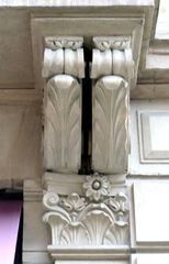 N° 1, rue du Temple Neuf: consoles doubles avec motif floral du balcon surplombant un commerce.
