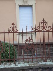 Grille séparant la façade du trottoir