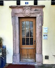 Porte d'entrée avec cartouche rococo. Le vantail date sans doute du XXe siècle