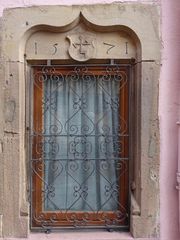 Fenêtre ornée d'un arc en accolade avec la date 1571 sur le linteau